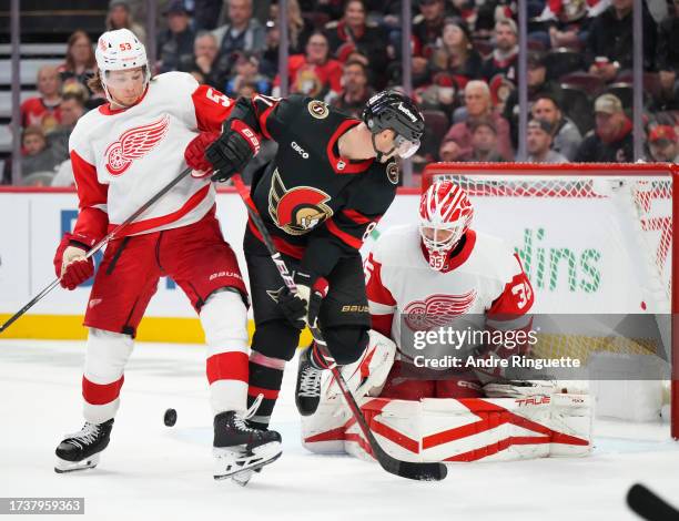 Dominik Kubalik of the Ottawa Senators battles for position against Moritz Seider of the Detroit Red Wings in front of Ville Husso at Canadian Tire...