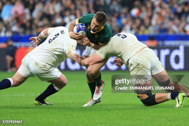 South Africa's fly-half Handre Pollard is tackled by England's tighthead prop Dan Cole and England's lock George Martin during the France 2023 Rugby...