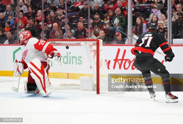 Ridly Greig of the Ottawa Senators scores a third period goal against Ville Husso of the Detroit Red Wings at Canadian Tire Centre on October 21,...