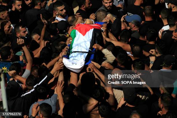 Mourners carry the body of 17-year-old Oday Mansour, a day after he was killed during the clashes with Israeli soldiers at a military checkpoint near...