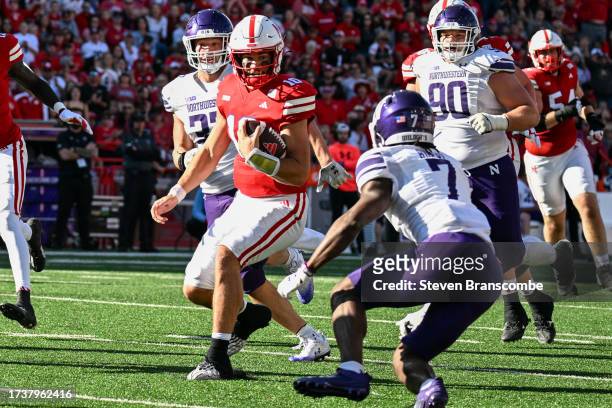Quarterback Heinrich Haarberg of the Nebraska Cornhuskers runs from defensive back Ore Adeyi of the Northwestern Wildcats in the second quarter at...