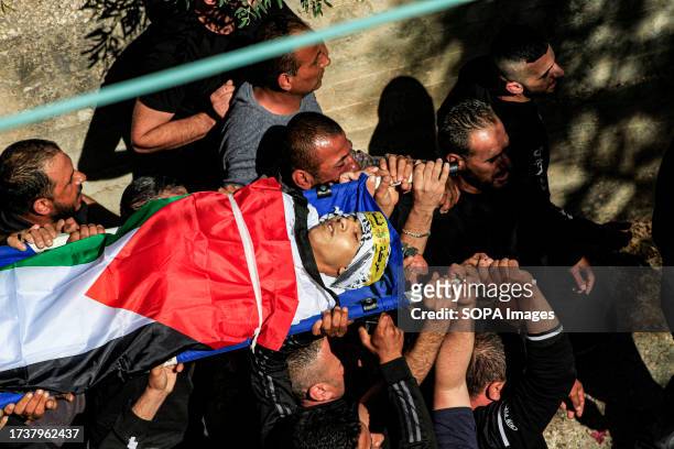 Mourners carry the body of 17-year-old Oday Mansour, a day after he was killed during the clashes with Israeli soldiers at a military checkpoint near...