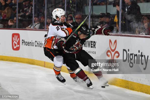 Travis Dermott of the Arizona Coyotes battles for possession with Mason McTavish of the Anaheim Ducks during the second period at Mullett Arena on...