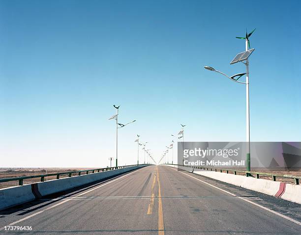 street lamps powered by wind & solar - single yellow line stock pictures, royalty-free photos & images