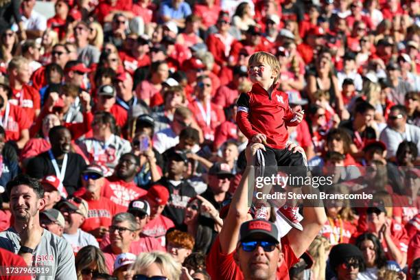 Dad holds a child up during the Simba Cam feature during the game between the Nebraska Cornhuskers and the Northwestern Wildcats in the third quarter...