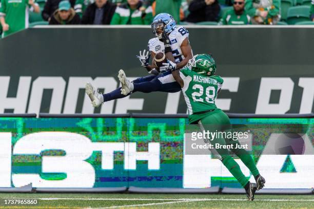 Damonte Coxie of the Toronto Argonauts goes high to make a catch over the coverage of Trumaine Washington of the Saskatchewan Roughriders in the game...