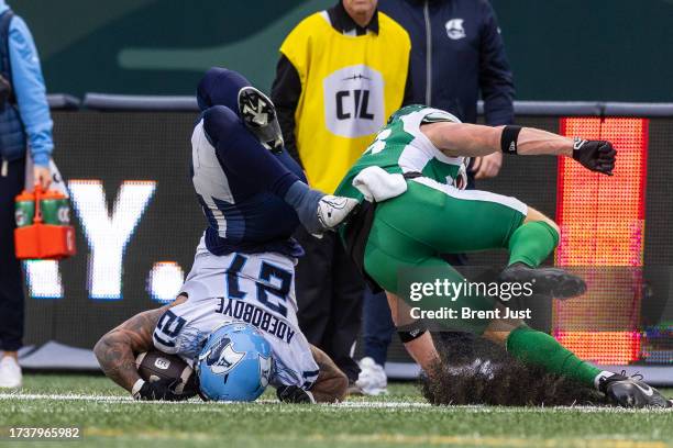 Daniel Adeboboye of the Toronto Argonauts lands awkwardly after trying to hurdle a Roughrider defender in the game between the Toronto Argonauts and...