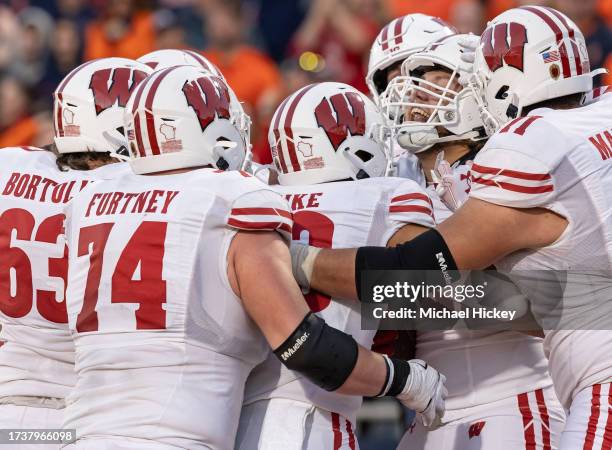 Isaac Townsend of the Wisconsin Badgers celebrates with team members after a go ahead touchdown against the Illinois Fighting Illini late in the...