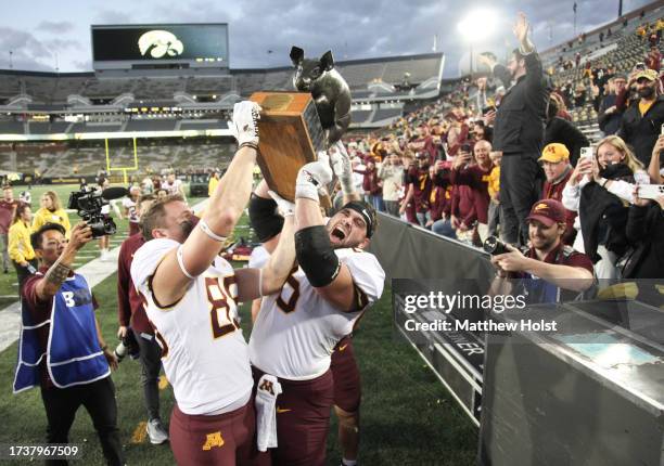 Tight end Frank Bierman and offensive lineman Nathan Boe celebrate the Floyd of Rosedale trophy after their match-up against the Iowa Hawkeyes at...