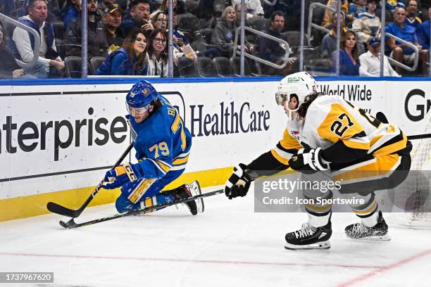 Pittsburgh Penguins defenseman Ryan Graves tries to poke the puck away from St. Louis Blues left wing Sammy Blais during a regular season game...