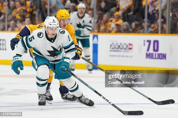 Matt Benning of the San Jose Sharks skates against Michael McCarron of the Nashville Predators during an NHL game at Bridgestone Arena on October 21,...