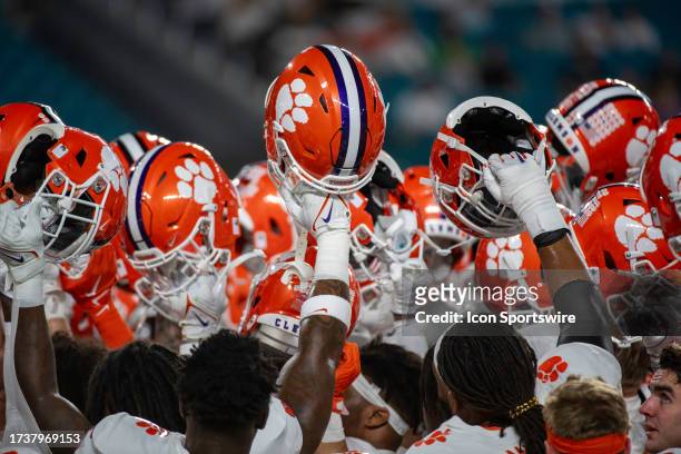 Clemson players hold their helmets up in a huddle on the field before the college football game between the Clemson Tigers and the University of...