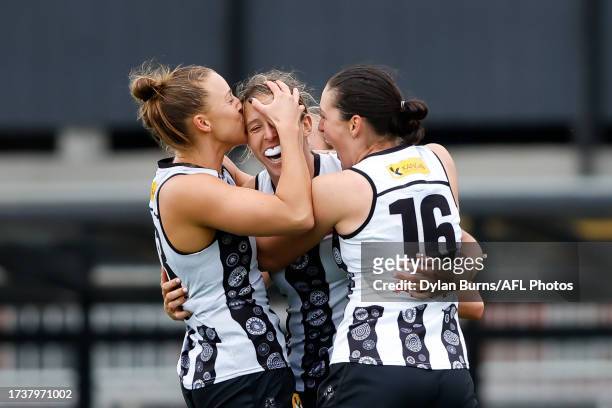 Erica Fowler of the Magpies celebrates a goal with teammates Ruby Schleicher and Sarah Sansonetti during the 2023 AFLW Round 08 match between The...