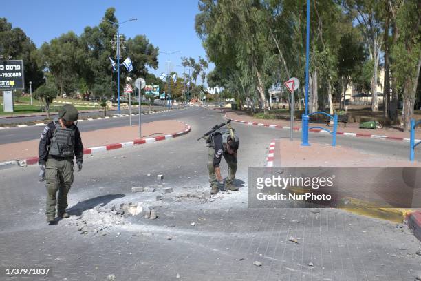 Israeli bomb squad team inspect the scene of a rocket hit , fired by Hamas from Gaza, in the Southern city of Sderot on October 21, 2023.