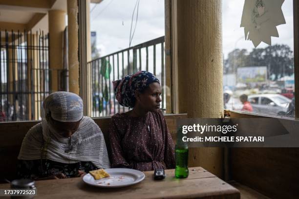 Woman looks out of the window of a restaurant in the historical Merkato district of Addis Ababa on October 21, 2023.