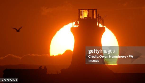 The sun rises over South Shields lighthouse after the top was ripped off, following Storm Babet which battered the UK, causing widespread flooding...