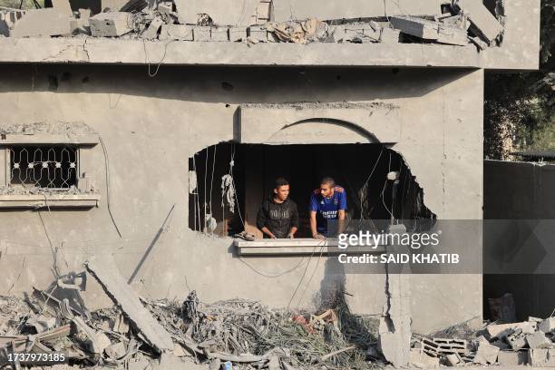Palestinian look out a window in a damaged building after Israeli strikes on Rafah in the southern Gaza Strip on October 22, 2023 amid the ongoing...