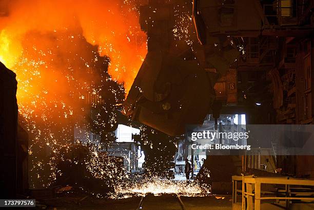 An employee stands near a cauldron of molten metal in the converter shop at OAO Mechel's metallurgical plant in Chelyabinsk, Russia, on Wednesday,...