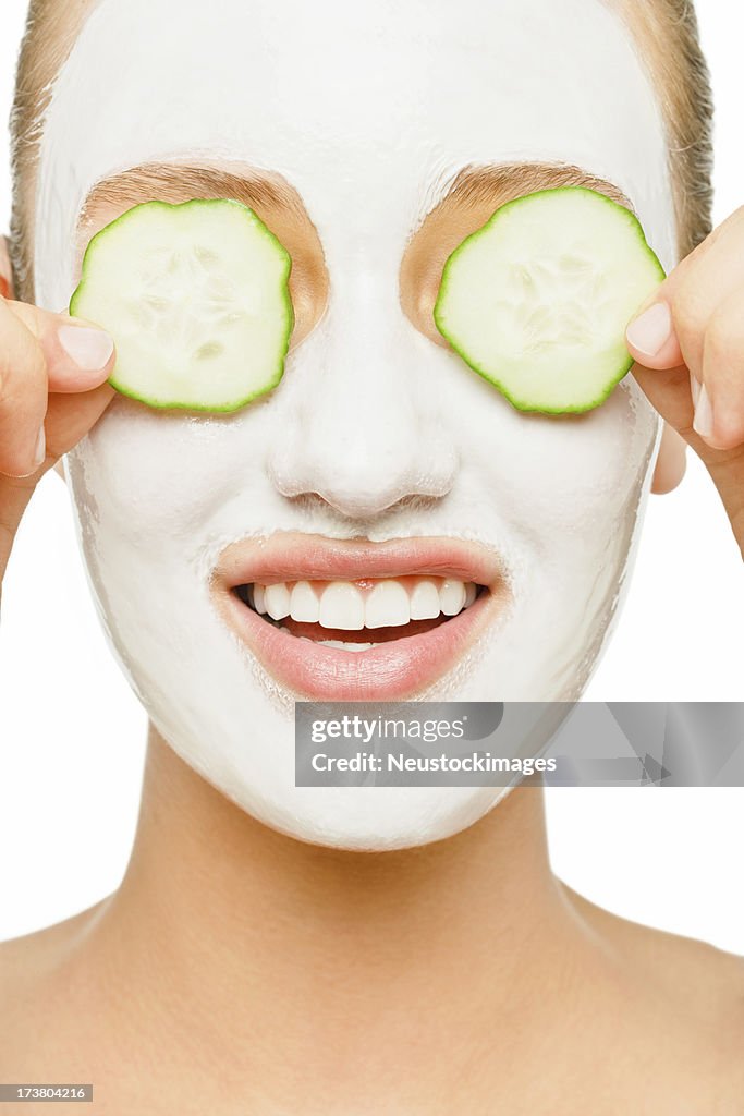 Young woman applying facial mask