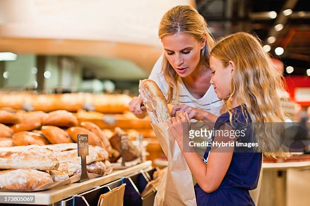 mother and daughter in grocery store - supermarket bread stock pictures, royalty-free photos & images