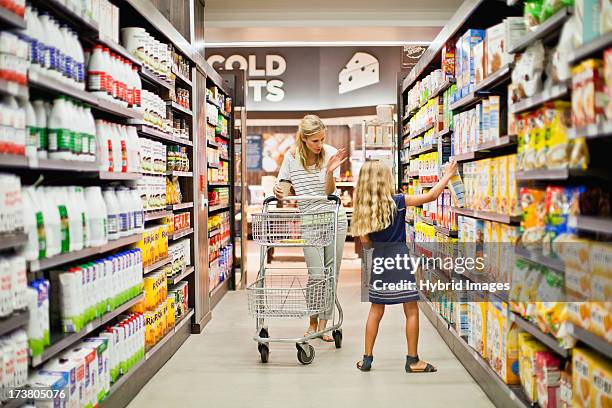 mother and daughter in grocery store - cereal box stock-fotos und bilder