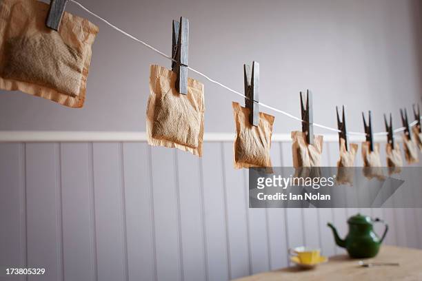 teabags hanging from clothesline - tea bag stock-fotos und bilder