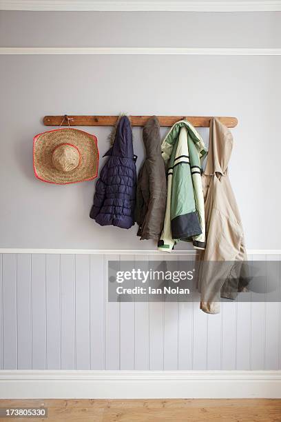 coats and hat on coat rack - hat rack bildbanksfoton och bilder