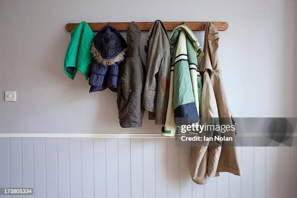 coats hanging on coat rack - coat stand stock pictures, royalty-free photos & images