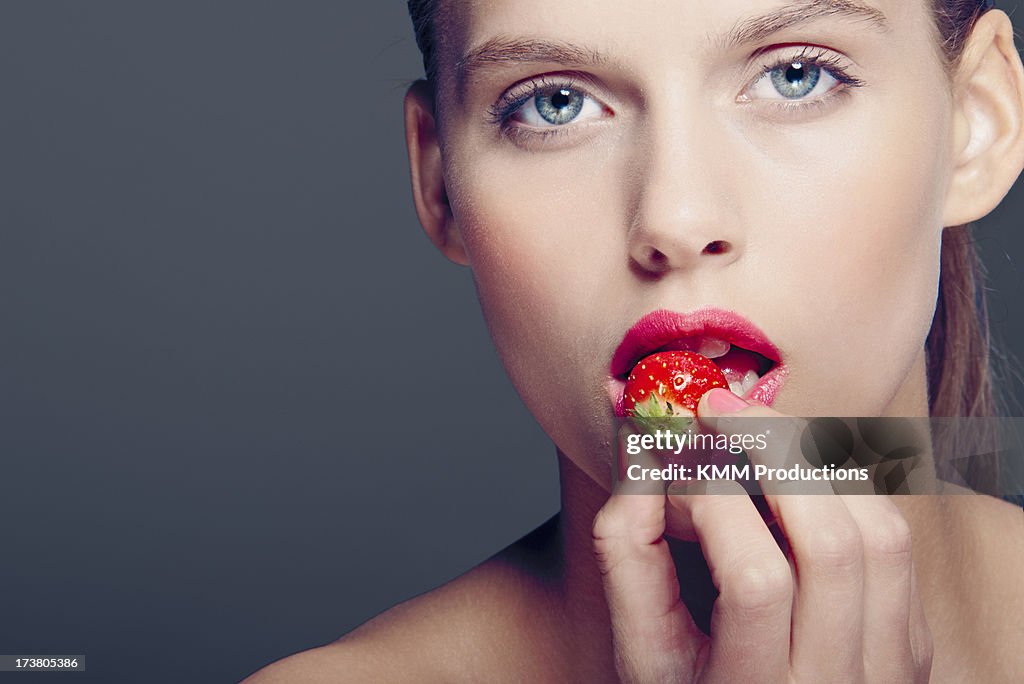 Woman eating strawberry