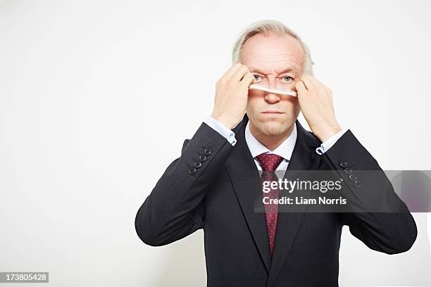 businessman pulling on mask - mask disguise stockfoto's en -beelden