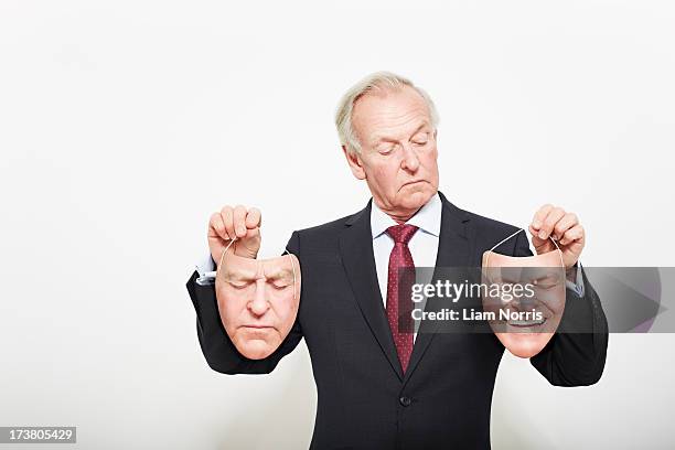 businessman holding masks - theatrical masks foto e immagini stock