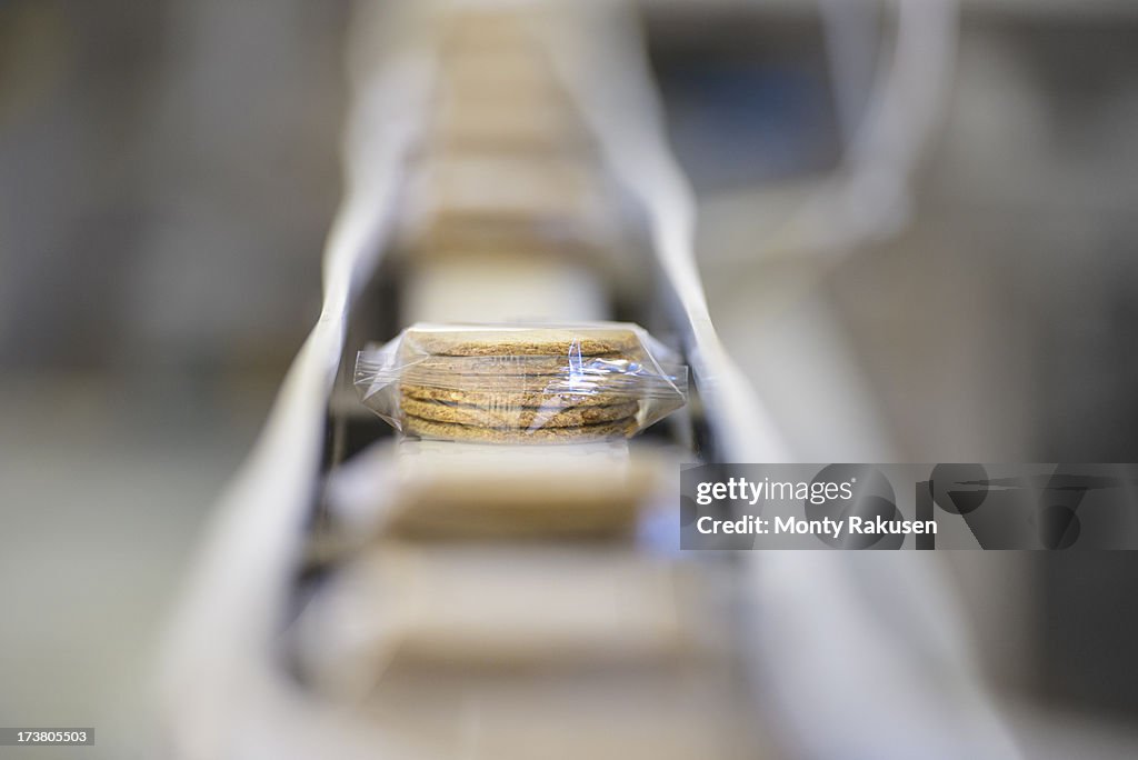 Selective focus of freshly made biscuits on production line in food factory