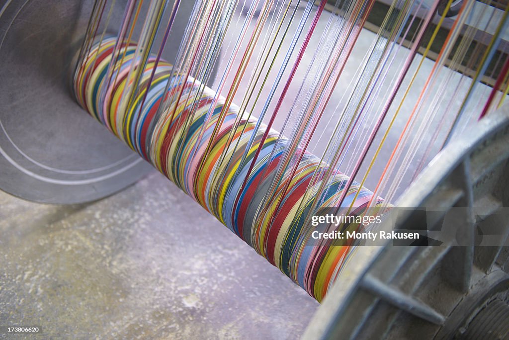 Multicoloured silk yarn on industrial loom in textile mill