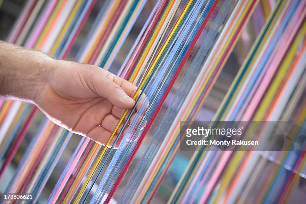 worker adjusting multicoloured silk yarn on industrial loom in textile mill - fábrica textil fotografías e imágenes de stock