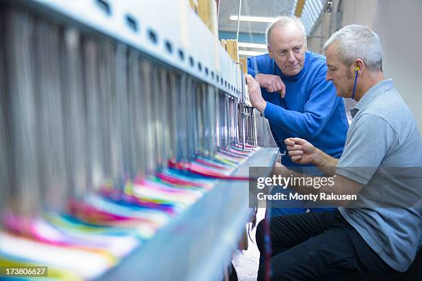 worker teaching apprentice to use industrial loom in textile mill - textile factory stock pictures, royalty-free photos & images