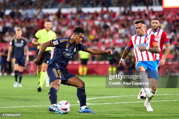 Jude Bellingham of Real Madrid CF passes the ball whilst under pressure from Aleix Garcia of Girona FC during the LaLiga EA Sports match between...