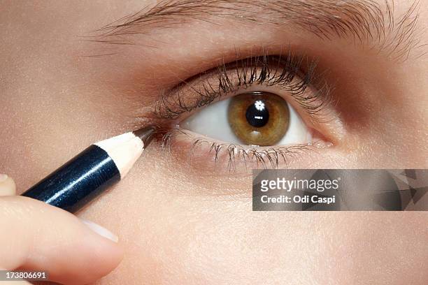close up of woman applying makeup - eyeliner stock-fotos und bilder