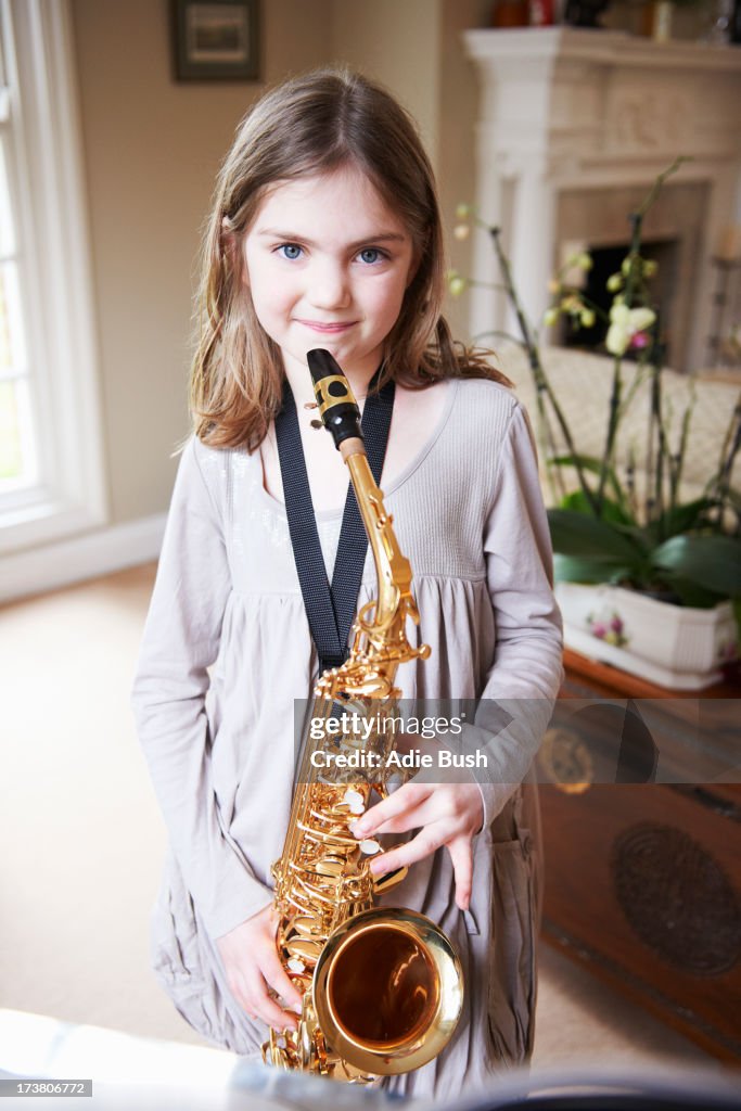 Smiling girl playing saxophone