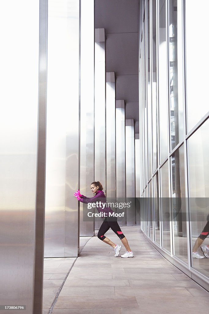 Woman stretching on city street