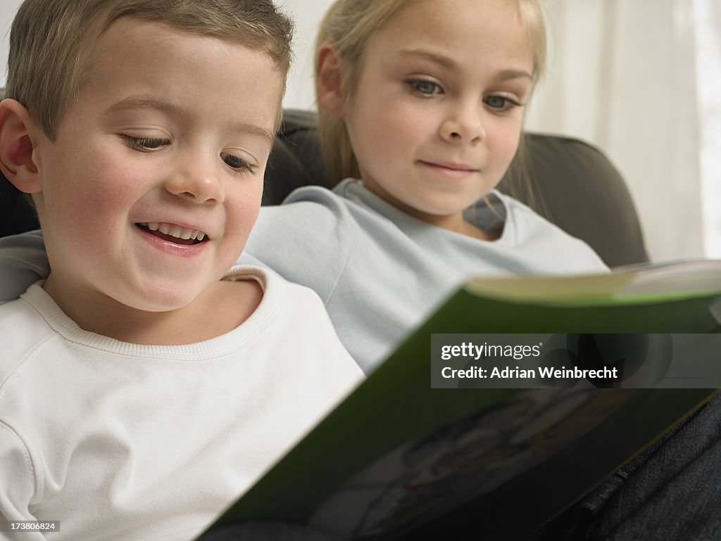 Children reading together on sofa