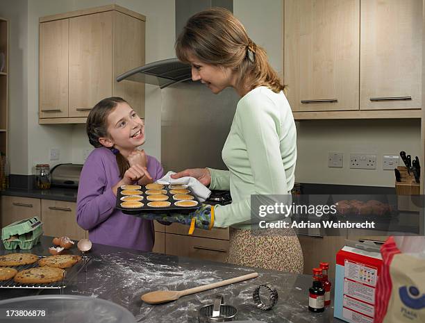 mother and daughter baking together - fragen beim kochen stock-fotos und bilder