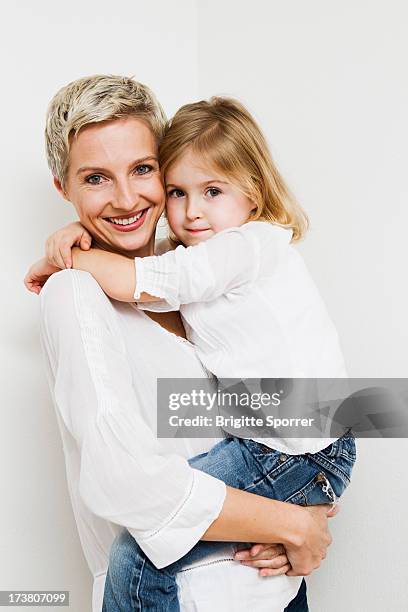 smiling mother and daughter hugging - family isolated stock-fotos und bilder