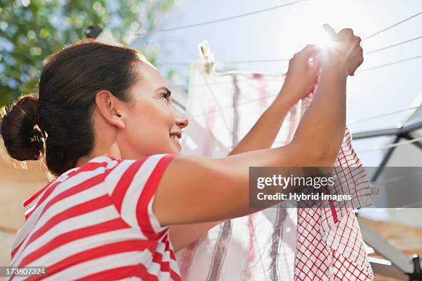 woman hanging clothes up on line - clothesline imagens e fotografias de stock