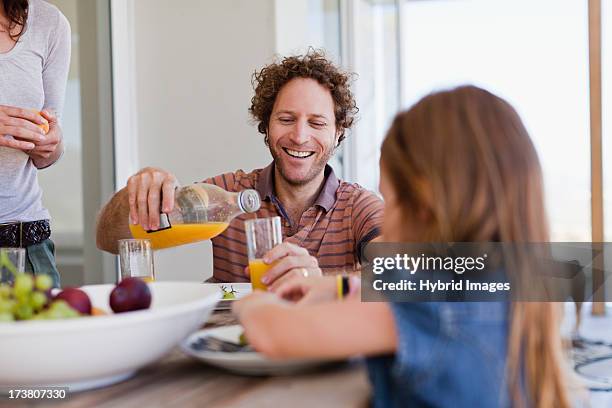 family having breakfast together - family orange juice foto e immagini stock