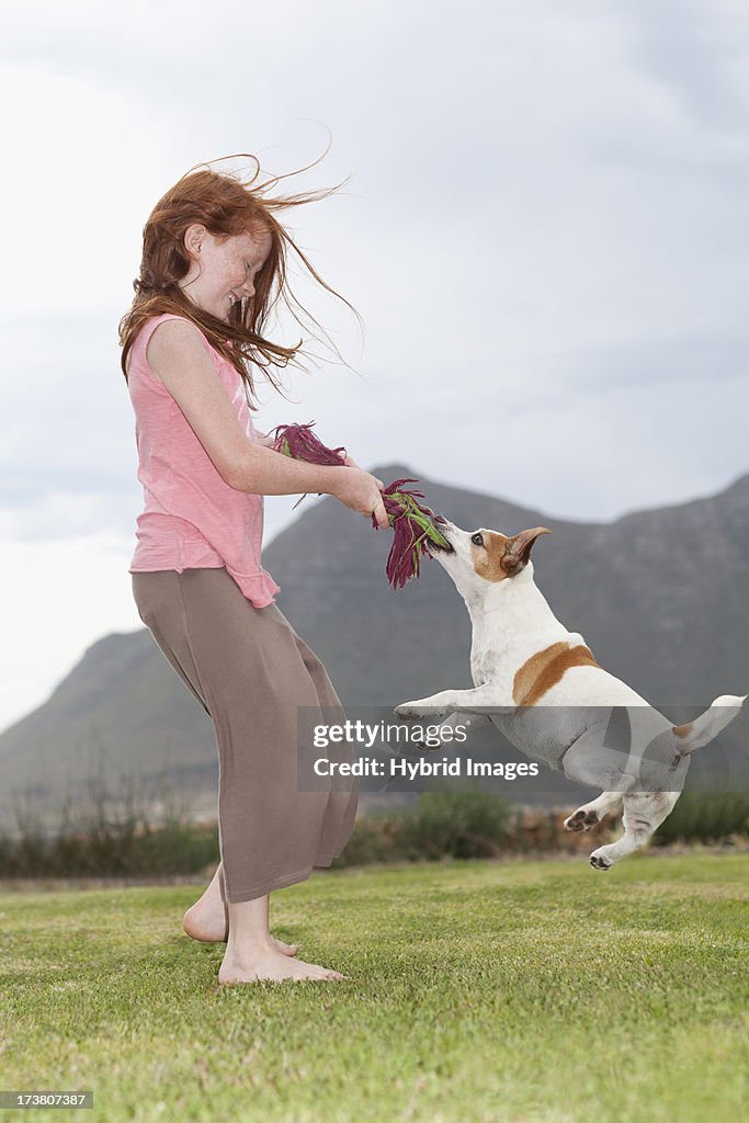 Girl playing with dog in grass