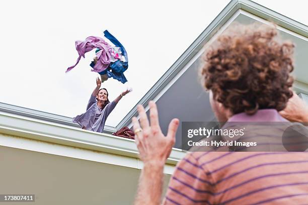 woman throwing out boyfriends clothes - couple breakup stock pictures, royalty-free photos & images