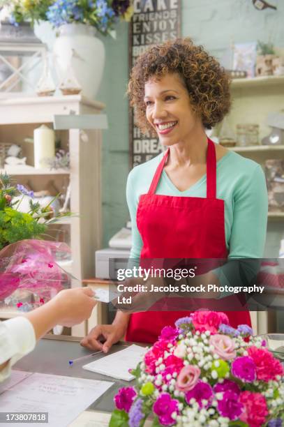 mixed race woman working in florist shop - equal pay stockfoto's en -beelden