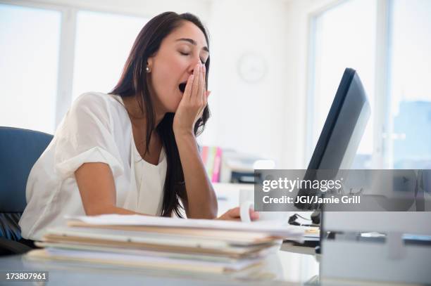 caucasian businesswoman yawning at desk - yawn office stock pictures, royalty-free photos & images