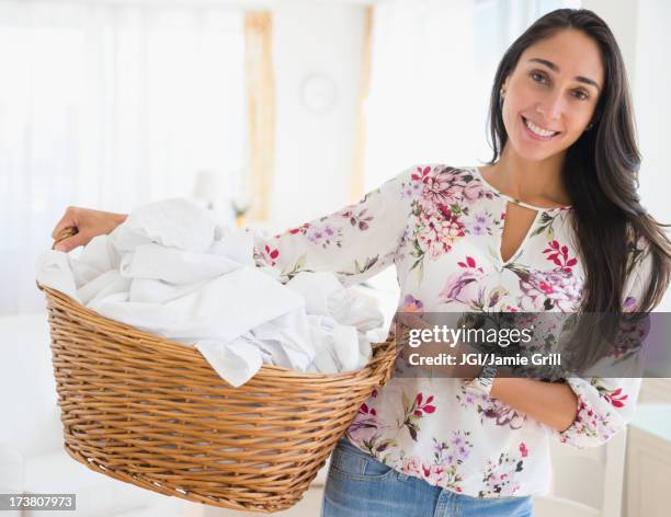 caucasian woman carrying basket of laundry - laundry basket foto e immagini stock