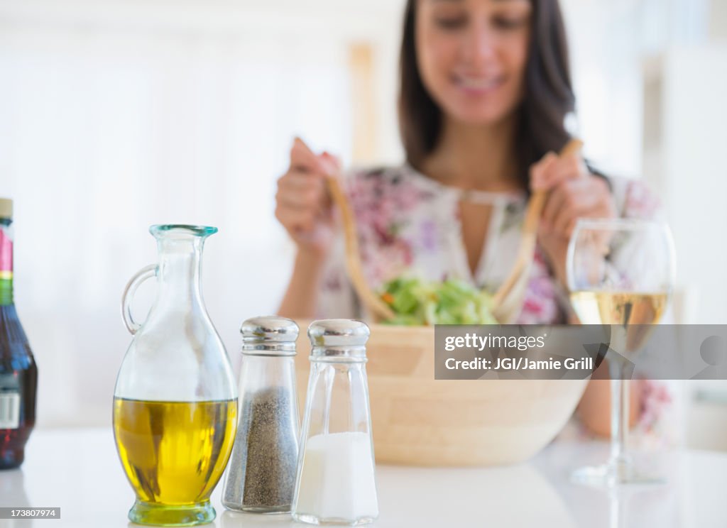 Caucasian woman tossing salad at lunch